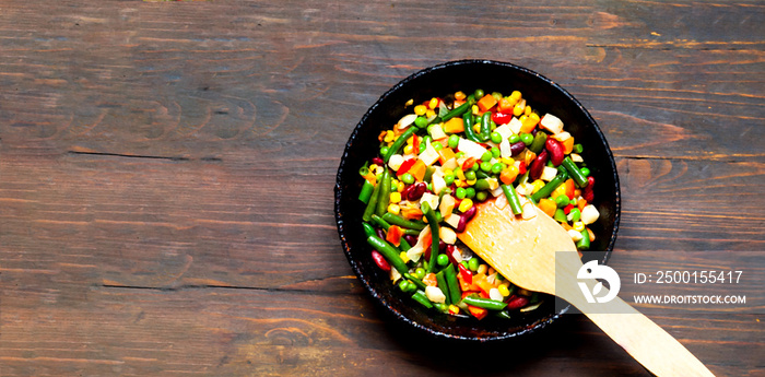 Vegetable mix in authentic pan on wooden background. Mexican food concept. Budget-friendly menu. Close-up