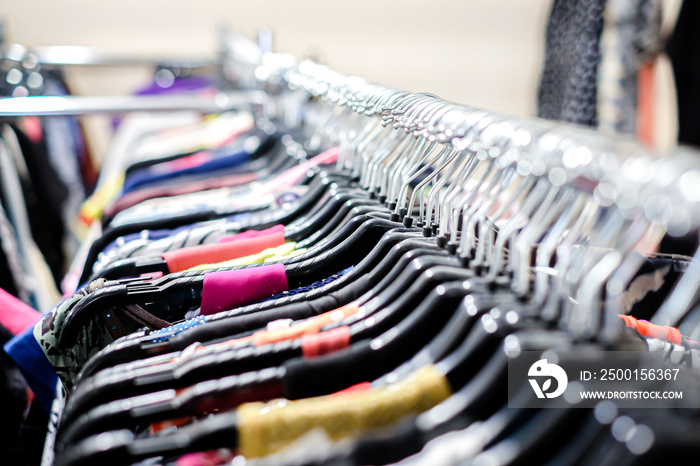 Second hand clothes store. Vintage clothes on the hangers. Defocused