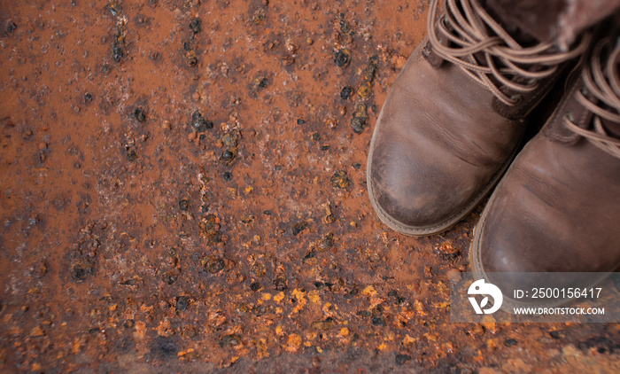 Men fashion brown boots with zipper on iron background.