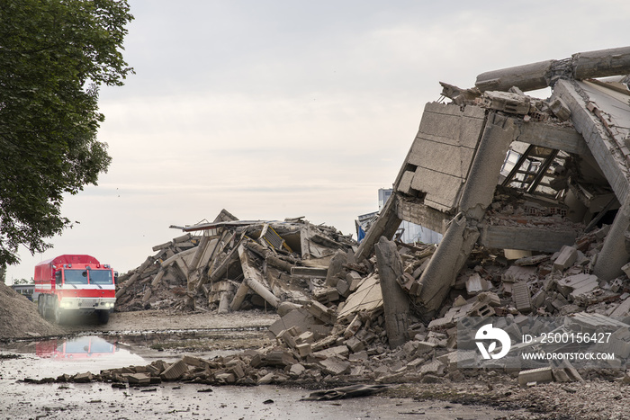 Fire brigade car among collapsed concrete buildings