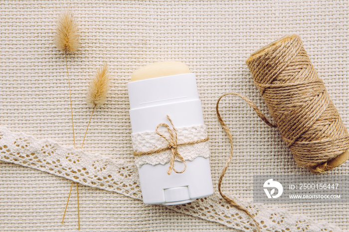 Making homemade deodorant stick with all natural ingredients concept. Flat lay view of refill container with natural antiperspirant on vintage background.