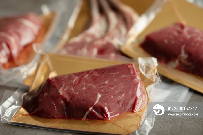 Raw meat vacuum-packed,  steaks on a wooden board.