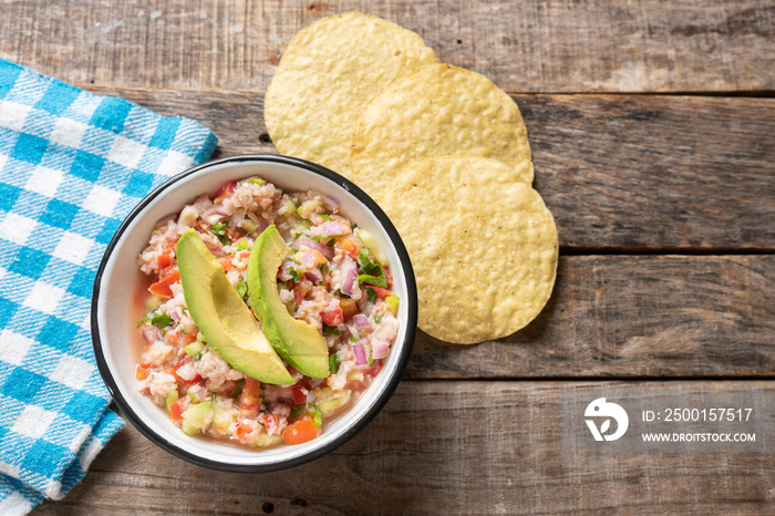 Mexican fish  ceviche with avocado on wooden background