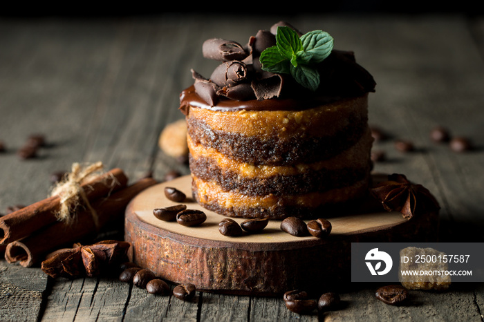 Chocolate cakes on black slatter board with mint, coffee beans on dark background, closeup photo. Fresh, tasty dessert food concept.