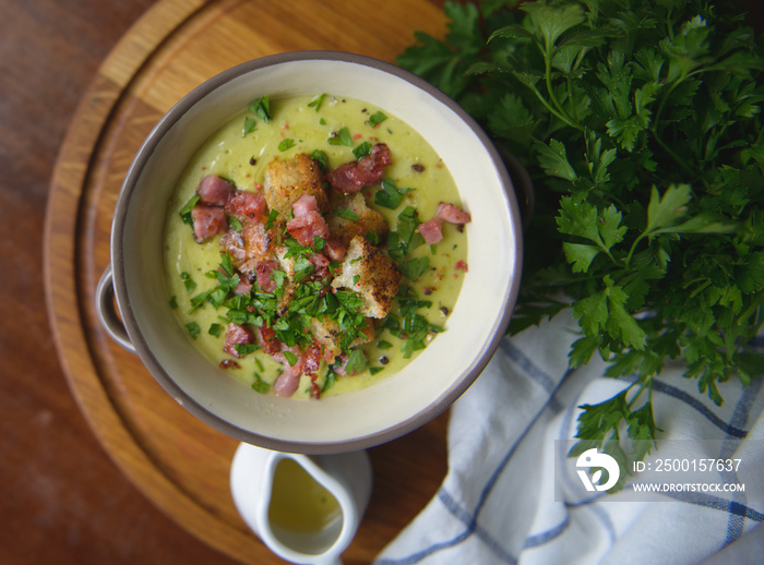 Soup with croutons and ham on the table