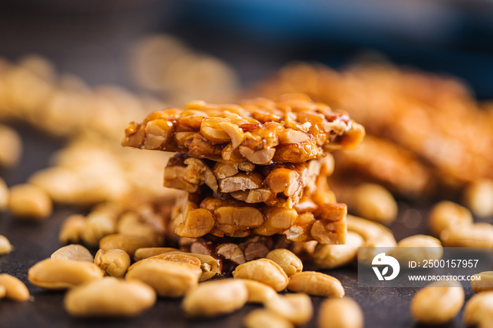 Sweet peanut brittle. Tasty peanuts in caramel on kitchen table.