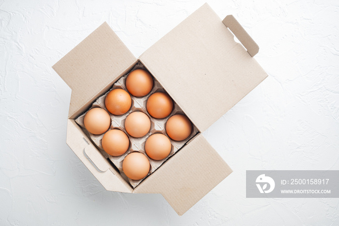 Fresh eggs on paper egg box, on white background, top view flat lay , with space for text  copyspace