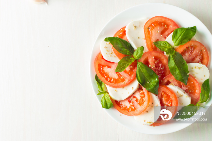 Close-up photo of caprese salad with ripe tomatoes, basil, buffalo mozzarella cheese. Italian and Mediterranean food concept. Fresh and healthy organic meal. Starter and antipasti.