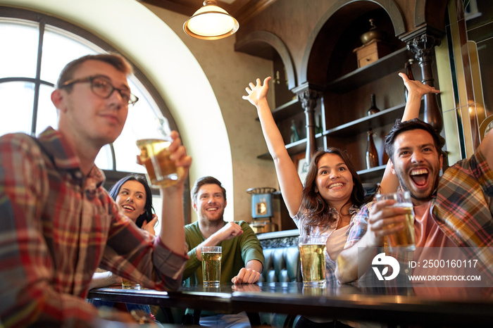 friends with beer watching football at bar or pub