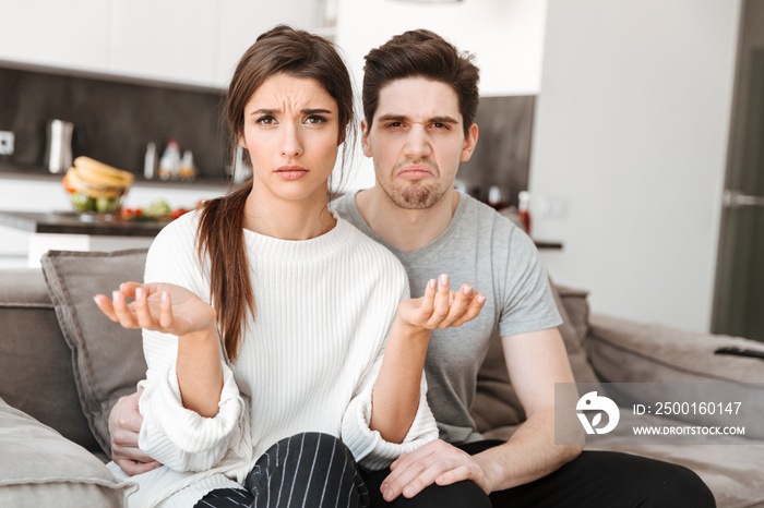 Portrait of an upset displeased couple sitting together