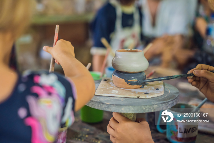 mother and son doing ceramic pot in pottery workshop