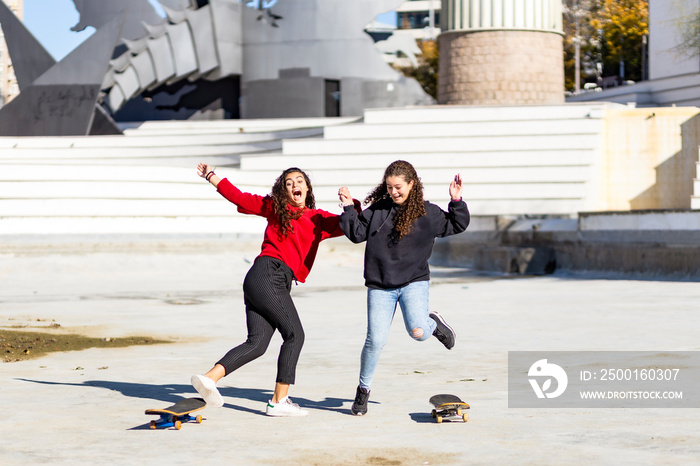 Two teen skaters about to fall off their skating boards