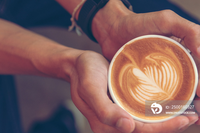 Close up hands of man sitting office desk holding sweet coffee cup relax and enjoy with happy time. Hot coffee mug in hand. Man holding coffee cup relaxing after work at office warm taste in cafe