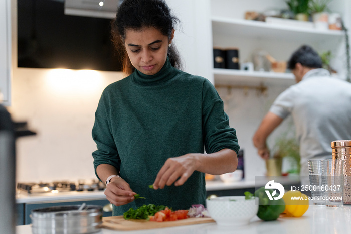 Woman and man preparing food in kitchen