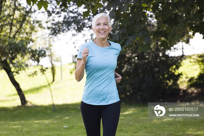 Senior woman jogging through park