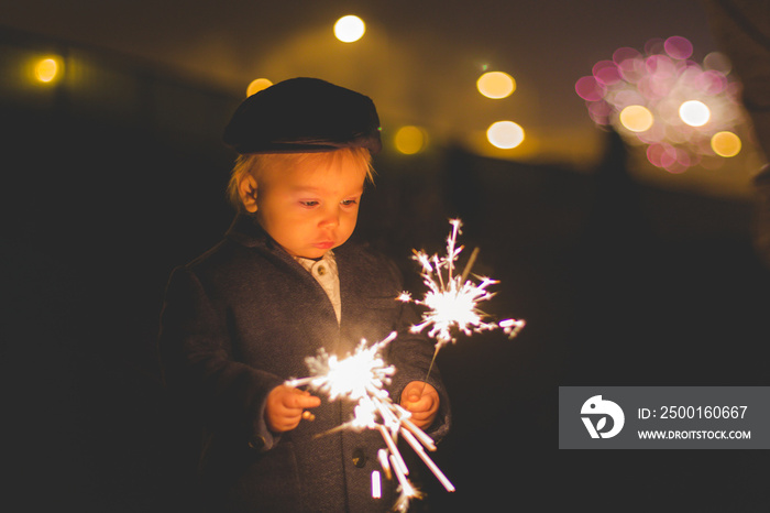 Waist up portrait of happy family celebrating New Year together and lighting sparklers outdoors