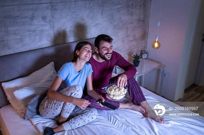 Couple watching a movie in bed