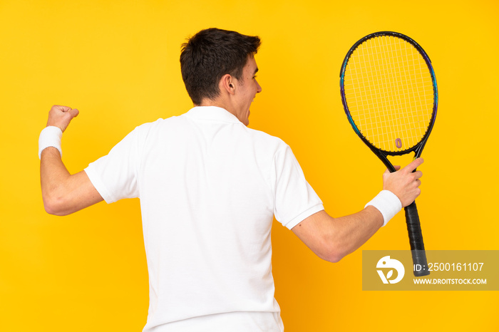 Handsome teenager tennis player man isolated on yellow background playing tennis and celebrating a victory