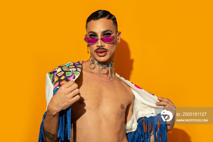 young drag queen in colorful dress on yellow background