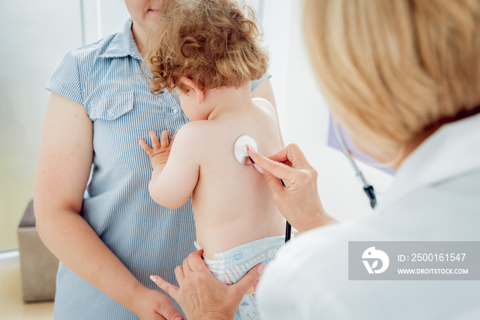 Friendly doctor pediatrician with patient child at clinic