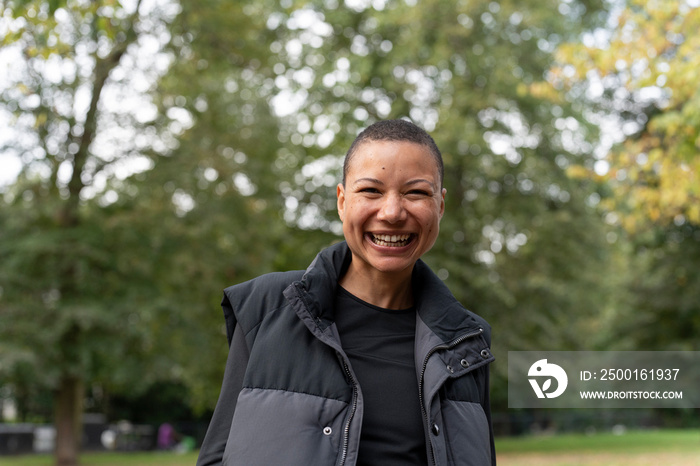 Portrait of smiling woman in sports clothing in park