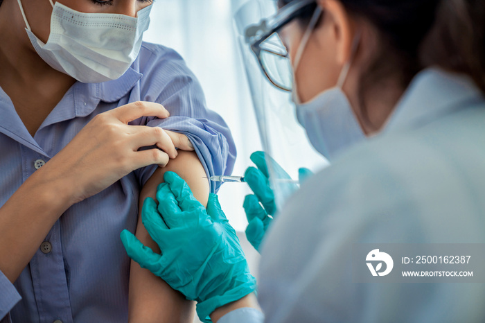 Young woman visits skillful doctor at hospital for vaccination . Covid 19 and coronavirus vaccination center service concept .