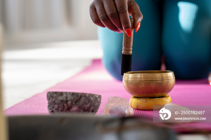 Close-up of woman with singing bowl in yoga studio