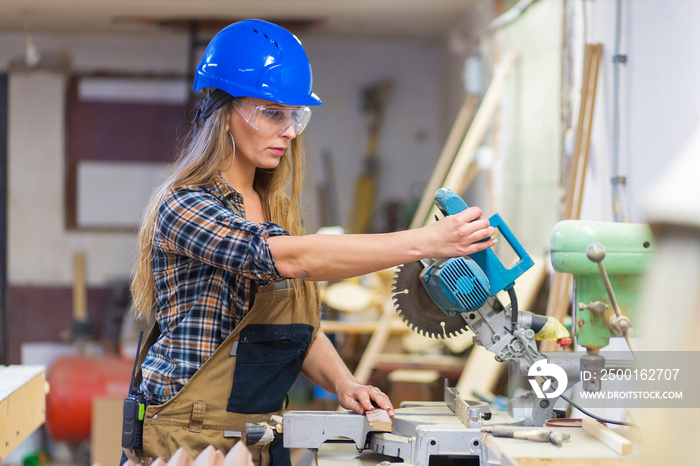 young woman with helmet working in a workshop