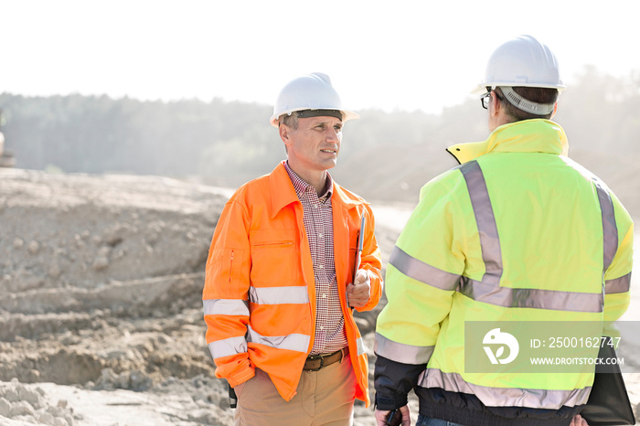 Supervisors discussing at construction site on sunny day