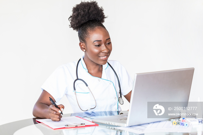 African American Doctor working in hospital writing a prescription, Healthcare and medical concept,test results in background, Stethoscope with clipboard and Laptop on desk