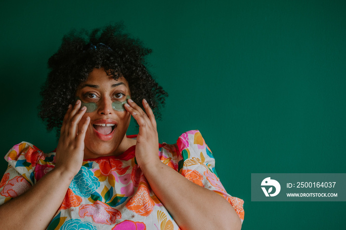 closeup of a plus size black person applying cooling eye pads