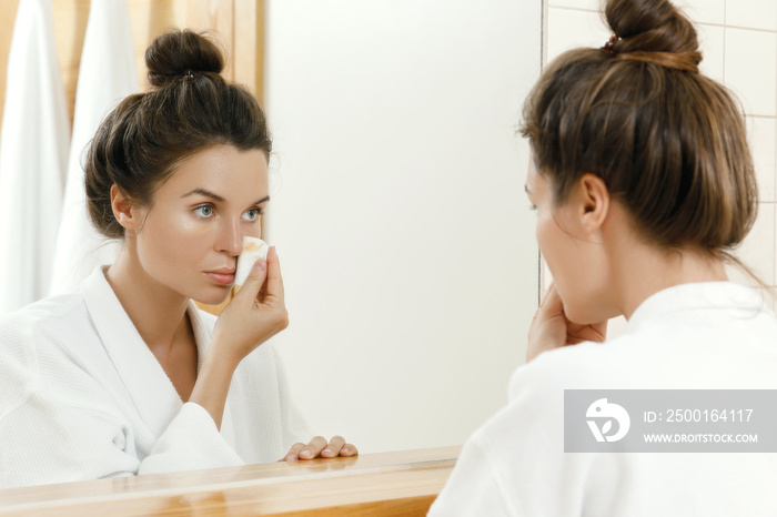 Woman removing makeup with a cotton pad