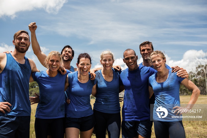 Group of fit people posing together in boot camp