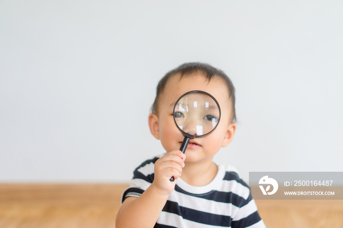 little baby boy looking through a magnifying glass.Concept for eyesight, eyes health concept.