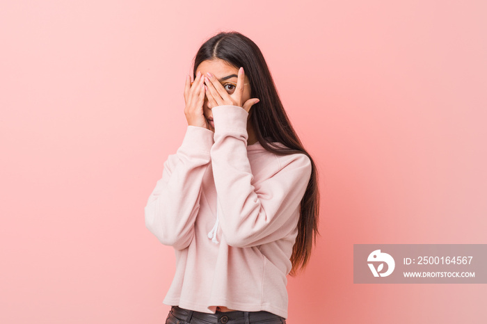 Young pretty arab woman wearing a casual sport look blink through fingers frightened and nervous.