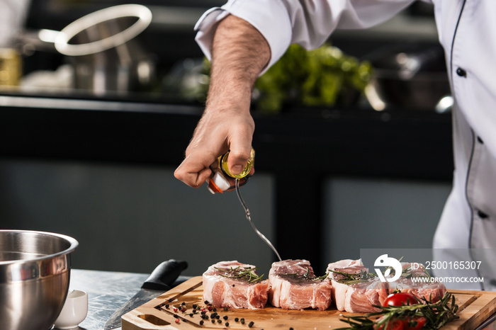 Chef hands pour meat at kitchen restaurant. Closeup chef hands spray beef.