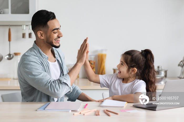 Handsome arab single father helping daughter with homework