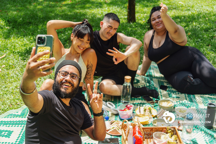 Group of friends having a picnic together at the park