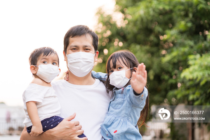 Asian father holding his daughter and son and all of people wear a mask to protect the corona virus and pm 2.5 dust in air, concept of people living in the crisis of covid-19 and air pollution problem