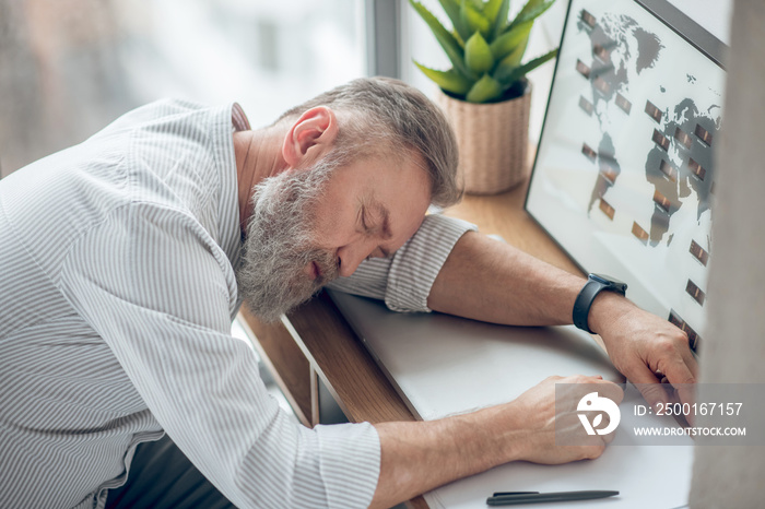 A man sleeping at the working place feeling tired