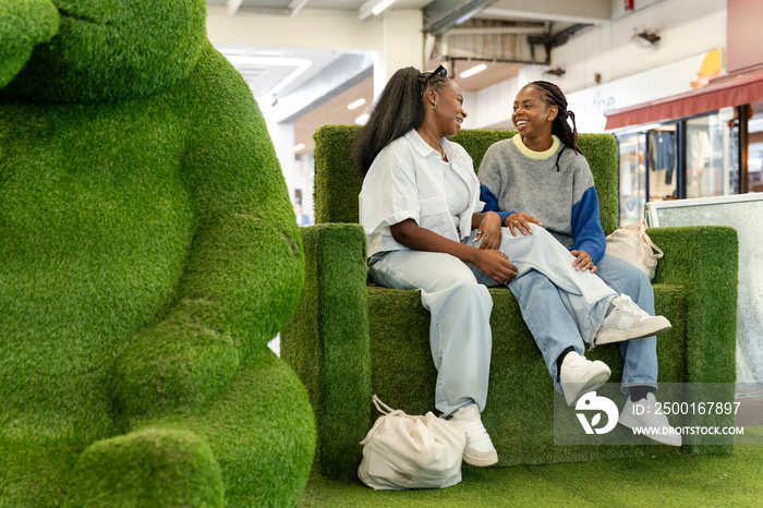 Young women relaxing on sofa in shopping center