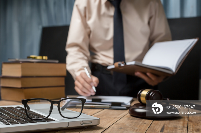 Business lawyer working hard at office desk workplace with book and documents.