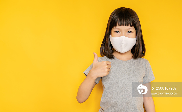 Portrait of asian little girl wearing mask protect from corona virus pm 2.5. Asia toddler girl thumb up surgical face mask against flu disease, epidemic virus social distancing, back to school concept