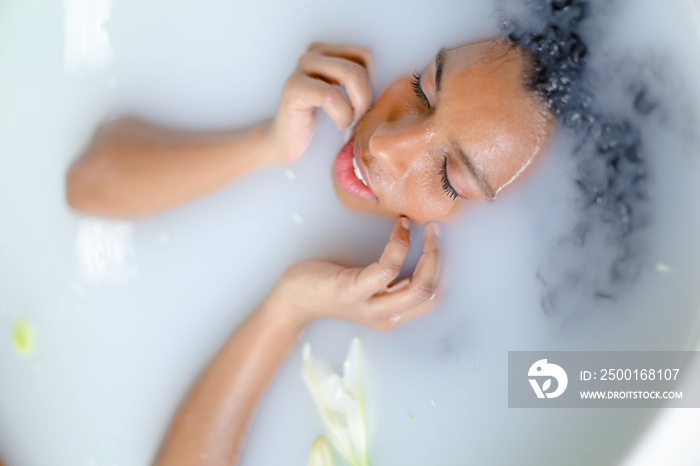 Close up portrait of black young girl taking milk bath.