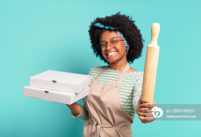 young pretty afro woman chef with a rolling pin and pizzas