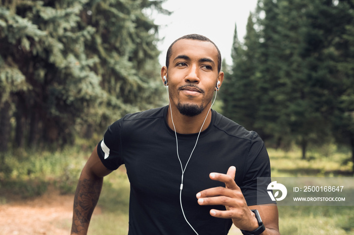 African-american man jogging and listening music outdoors