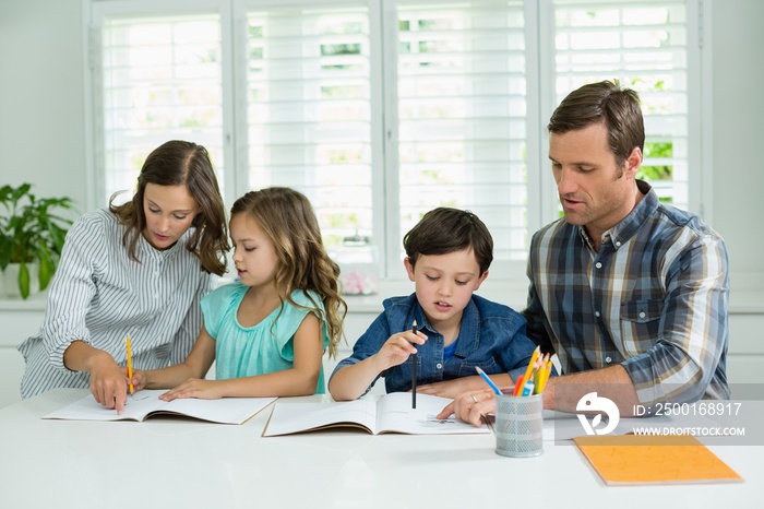 Siblings getting help with homework from parents