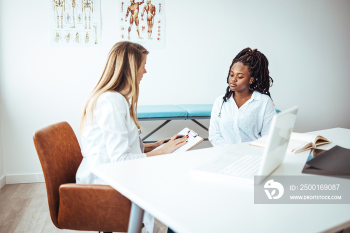 Female patient and doctor discussing test results in medical office. African American woman at a medical appointment with her doctor. Cropped shot of an attractive young female doctor consulting