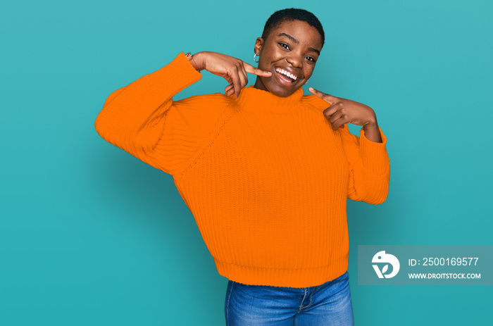 Young african american woman wearing casual clothes smiling cheerful showing and pointing with fingers teeth and mouth. dental health concept.