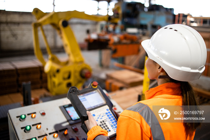 Factory worker operating production machine using industrial computer.